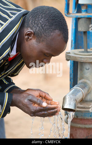 Giugno 21, 2012 - Villaggio lucrativa 2 (villaggio, dello Zimbabwe - Giugno 21, 2012, Makonde, dello Zimbabwe - un abitante di un villaggio bevande acqua pulita, fresca da un foro praticato dal CRS attraverso l'agenzia partner della Caritas dello Zimbabwe nel quartiere Makonde dello Zimbabwe. CRS trapanato il foro di trivellazione nel 2011 attraverso la Caritas Zimbabwe come parte dell'Enhanced Acqua Rurale misure sanitarie e igieniche (ER LAVAGGIO) progetto, consentendo agli abitanti del villaggio per poi iniziare una nutrizione nelle vicinanze giardino sul proprio con l'acqua dal pozzo di trivellazione disponibili per irrigazione. (Credito Immagine: © David Snyder/ZUMAPRESS.com) Foto Stock