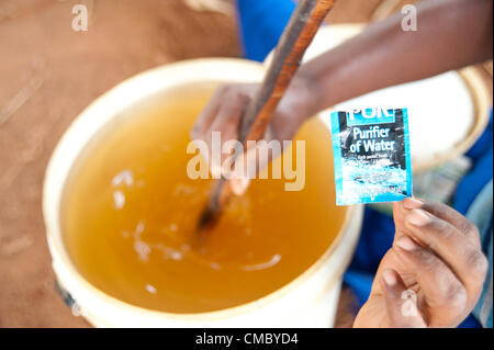 Giugno 21, 2012 - (lucrativa Village, dello Zimbabwe - Giugno 21, 2012, Makonde, dello Zimbabwe - un membro della Takupuka risparmi e prestiti interni (SILC) mix di gruppo di purificazione dell'acqua compresse in acqua di fiume usato per bere da altri membri della comunità del villaggio di Gainfull, Zimbabwe. CRS ha iniziato il gruppo nel 2011 come parte dell'Enhanced Acqua Rurale misure sanitarie e igieniche (ER lavaggio), progetto di risparmio che sono visti come un elemento chiave di tale strategia. Con i soldi di risparmio, i membri possono acquistare essentials come queste compresse da negozi locali. (Credito Immagine: © David Snyder/ZUMAPRESS.com) Foto Stock