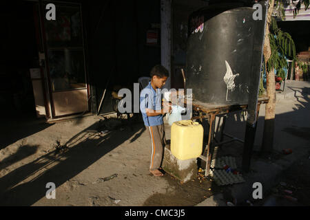 Luglio 14, 2012 - Rafah nella striscia di Gaza, Territori palestinesi - un bambino palestinese si riempie di flaconi di acqua potabile in Rafah Refugee Camp nel sud della striscia di Gaza il 14 luglio 2012 (credito Immagine: © Eyad Al Baba APA/images/ZUMAPRESS.com) Foto Stock