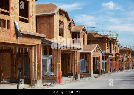 Luglio 19, 2012 - Aliso Viejo, California, Stati Uniti - Un equipaggio di costruzione lavora su una nuova casa in Aliso Viejo in Orange County. Nuovi Stati Uniti home costruzione sorse nel giugno al livello più alto in quasi quattro anni, indicando il mercato immobiliare residenziale è rafforzare anche in altre parti dell'economia cool. Inizio costruzione di case degli Stati Uniti è aumentato più di quanto previsto in giugno al tasso più veloce in quasi quattro anni, indicando un più luminoso di outlook per il mercato immobiliare residenziale. Alloggiamento inizia rose 6,9 percento a 760,000 un ritmo annuale dopo una revisione del tasso di 711,000 in maggio che è stato più veloce th Foto Stock