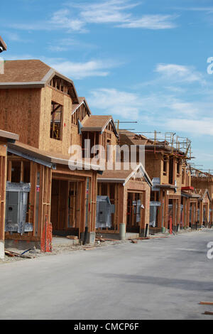 Luglio 19, 2012 - Aliso Viejo, California, Stati Uniti - Un equipaggio di costruzione lavora su una nuova casa in Aliso Viejo in Orange County. Nuovi Stati Uniti home costruzione sorse nel giugno al livello più alto in quasi quattro anni, indicando il mercato immobiliare residenziale è rafforzare anche in altre parti dell'economia cool. Inizio costruzione di case degli Stati Uniti è aumentato più di quanto previsto in giugno al tasso più veloce in quasi quattro anni, indicando un più luminoso di outlook per il mercato immobiliare residenziale. Alloggiamento inizia rose 6,9 percento a 760,000 un ritmo annuale dopo una revisione del tasso di 711,000 in maggio che è stato più veloce th Foto Stock