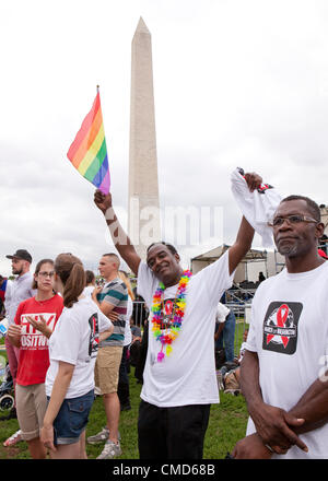 Un uomo sventola una bandiera arcobaleno di fronte al monumento di Washington in Washington, DC - Domenica, 22 Luglio 2012 Foto Stock