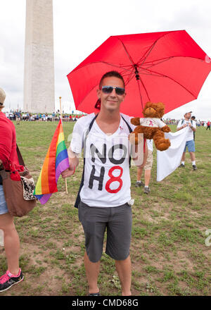 Un uomo può contenere fino a bandiera arcobaleno davanti al Monumento di Washington, come egli si prepara per l'AIDS Marzo - Luglio 22, 2012, Washington DC, Stati Uniti d'America Foto Stock