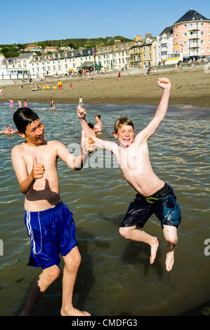 Martedì 24 luglio 2012. Aberystwyth, Wales, Regno Unito. Il clima caldo continua in tutto il Regno Unito con temperature in alta 20s (in gradi celsius). Persone godetevi il sole sulla spiaggia ed in mare in questo Welsh resort costiero. Foto Stock