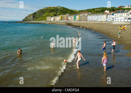 Martedì 24 luglio 2012. Aberystwyth, Wales, Regno Unito. Il clima caldo continua in tutto il Regno Unito con temperature in alta 20s (in gradi celsius). Persone godetevi il sole sulla spiaggia ed in mare in questo Welsh resort costiero. Foto Stock