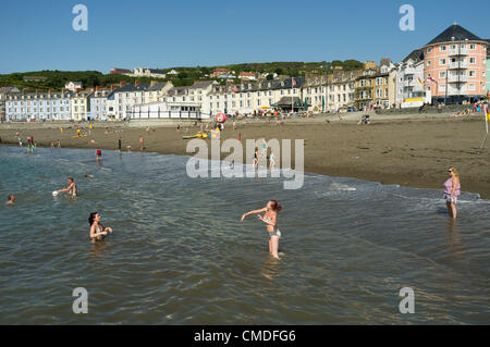 Martedì 24 luglio 2012. Aberystwyth, Wales, Regno Unito. Il clima caldo continua in tutto il Regno Unito con temperature in alta 20s (in gradi celsius). Persone godetevi il sole sulla spiaggia ed in mare in questo Welsh resort costiero. Foto Stock