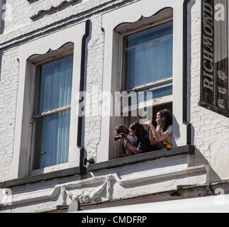 Hill Street, Richmond Upon Thames, London, Regno Unito, martedì 24 luglio 2012 persone a una finestra per scattare foto della folla in attesa. Il viaggio della torcia ha iniziato a Kingston intorno a 8.20am e arrivati al prosciutto a circa 9.50am. La torcia è poi passato attraverso Richmond e Kew prima voce su LB Hounslow a circa 11,25 am. Foto Stock