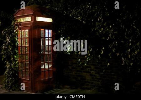 Luglio 26, 2012 - Londra, Inghilterra, Regno Unito - Il telefono rosso casella, progettato da Sir Giles Gilbert Scott, una volta onnipresente sulle strade del Regno Unito, sta diventando sempre più scarse. È il telefono è illuminata su un North London strada residenziale alla vigilia del giorno di apertura della Londra 2012 Olimpiadi di estate. (Credito Immagine: © Mark Makela/ZUMAPRESS.com) Foto Stock