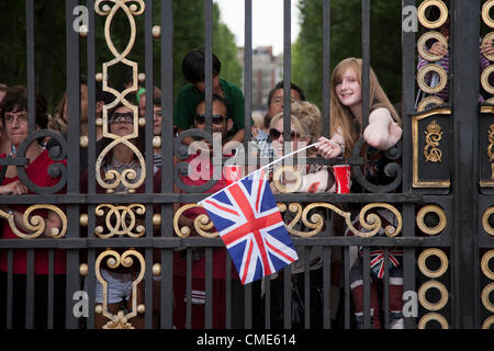 Spettatori guarda uomini della Olympic Escursioni in bicicletta da corsa su strada attraverso il Green Park Royal cancelli in Londra il 28 luglio 2012. La gara, che è passato da Buckingham Palace alla linea del traguardo sul Mall, è stato vinto da Alexander Vinokourov del Kazakistan Foto Stock