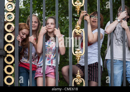 Persone salire Green Park Royal porte per ottenere una buona visualizzazione degli uomini della Olympic Escursioni in bicicletta da corsa su strada di Londra il 28 luglio 2012. Foto Stock