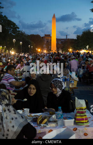 Istanbul, Turchia. Martedì 31 luglio 2012. Ramazan (Ramadan) è quasi la metà al di sopra. I musulmani picnic sulle tabelle fornite dal comune di Sultan Ahmet quartiere, la città vecchia di Istanbul, Turchia. Questa è la piazza di fronte alla Moschea Blu, con l'obelisco in background Foto Stock