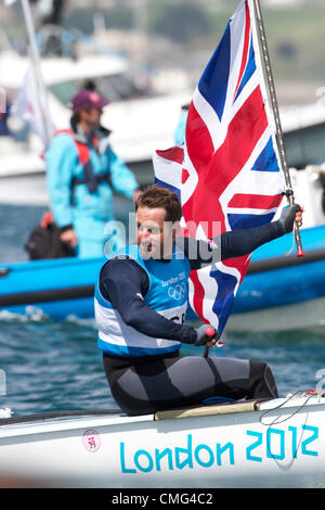 05.08.2012. Weymouth, Inghilterra. Giochi olimpici di vela a Weymouth Dorset, Agosto 2012. Tripla medaglia d'oro olimpica Ben Ainslie vince l'oro nella classe Finn e sventola una bandiera dell'Union Jack per la folla Foto Stock