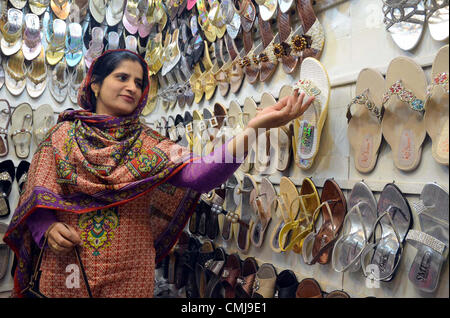 Donna occupati ad acquistare sandali durante Eid dello shopping al negozio al mercato Liaquat precedendo di Eid-ul-Fitar durante il mese sacro del Ramadan-ul-Mubarak a Quetta Mercoledì, 15 agosto 2012. Foto Stock