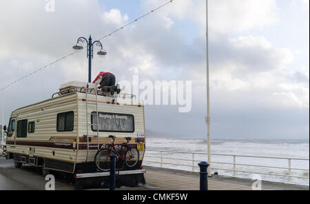 Aberystwyth Wales UK, sabato 2 novembre 2013 un proprietario caravan protegge il suo veicolo come avvisi vengono rilasciati per gale force venti in Aberystwyth Wales UK. Le risorse naturali del Galles (NRW) detto dieci avvertenze alluvione sono attualmente in vigore nelle zone costiere del Galles, con le preoccupazioni su alta marea. Raffiche di colpire 70 nodi (80mph) sono state riportate sulle coste esposte. Photo credit: keith morris/Alamy Live News/Alamy Live News Foto Stock