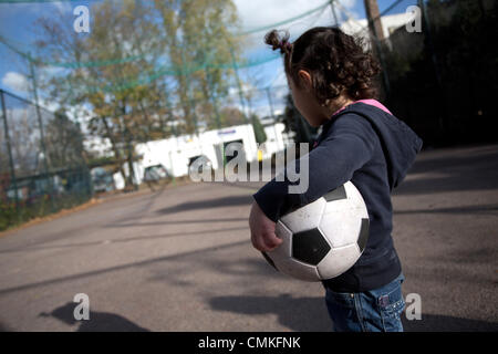 Berlin-Wedding, Germania. 30 ott 2013. Una ragazza sta con una sfera in una gabbia di calcio sul Panke in Berlin-Wedding, Germania, 30 ottobre 2013. Schalke's pro soccer player Kevin-Prince Boateng avrebbe imparato a giocare a calcio in questa gabbia. Foto: Joerg Carstensen/dpa/Alamy Live News Foto Stock