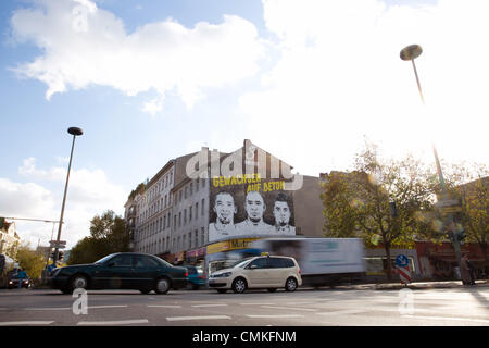 Berlin-Wedding, Germania. 30 ott 2013. Un sporting buon costruttore pubblicizza con le facce dei fratelli Girolamo (L-R), George e Kevin-Prince Boateng su una parete di un edificio in Berlin-Wedding, Germania, 30 ottobre 2013. Schalke's pro soccer player Kevin-Prince Boateng avrebbe imparato a giocare a calcio in questa gabbia. Foto: Joerg Carstensen/dpa/Alamy Live News Foto Stock