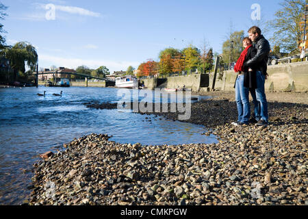 Il fiume Tamigi Twickenham Riverside. Giovane / persone in piedi sulla spiaggia / riverbank banca / letto molto durante la bassa marea, REGNO UNITO Foto Stock