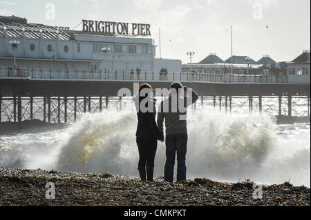 La gente guarda come una massiccia ondata si blocca sulla spiaggia di fronte al molo di Brighton durante una tempesta di neve a Brighton, East Sussex, Regno Unito. Foto Stock