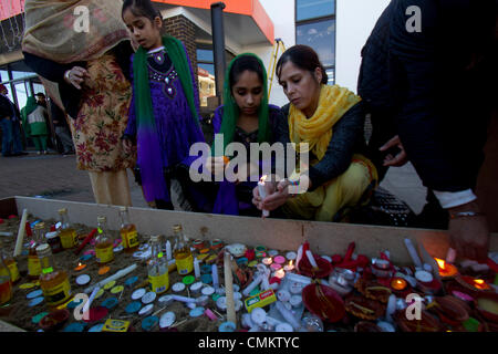 Southall Londra, Regno Unito. 3 novembre 2013. I membri della comunità sikh luce di lampade a olio e candele al di fuori di un tempio Gurdwara a Southall nel West London all'inizio delle celebrazioni Diwali conosciuta come la festa delle luci che segna l'inizio dell'Hindu nuovo anno che è celeberated da migliaia di indù nonché i sikh in tutto il Regno Unito . Diwali comporta l'illuminazione di argilla di piccole lampade riempite con olio a significare il trionfo del bene sul male. Credito: amer ghazzal/Alamy Live News Foto Stock