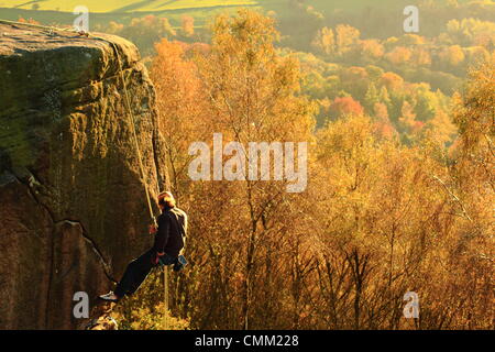 Un scalatore di pietra lo affronta Froggatt sopra il bordo della Valle del Derwent su un bel giorno di autunno nel Peak District, Derbyshire, in Inghilterra, Regno Unito Foto Stock