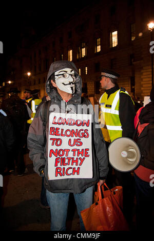 Londra, Regno Unito. 05/11/13. Un attivista detiene una targhetta, come su un 1000 attivisti provenienti da vari anti-gruppi di austerità protesta nel centro di Londra. 05/10/2013 Credit: Pete Maclaine/Alamy Live News Foto Stock