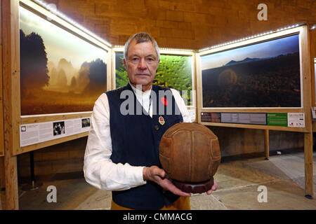 Londra, Regno Unito. 5 novembre 2013. Fotografo Mike San Maur Sheil con il calcio Loos (questo è il calcio che il London Irish fucili calci su No Mans Land su 25 Settembre 1915 come hanno attaccato le posizioni tedesche nella città di Loos) presso i campi di battaglia terre di pace 14-18 pre-lancio mostra a Westminster Hall, la Casa del Parlamento, il London. Annunciando un importante WWI commemorativa mostra di World Press Photo Award-winning fotografo Mike San Maur Sheil che lancerà a Londra nel 2014 e tour città inglesi per i prossimi quattro anni. Credito: Paul Brown/Alamy Live News Foto Stock