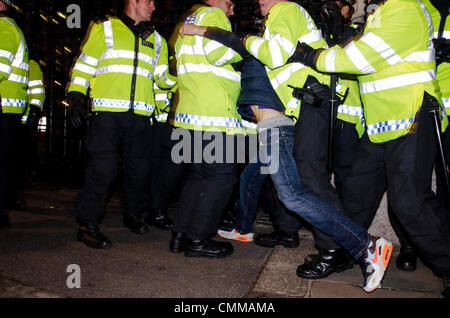 Londra, Regno Unito. 5 novembre 2013. La polizia scontri in piazza del Parlamento, LONDRA, REGNO UNITO, durante le proteste contro i tagli di austerità come parte del global anonimo movimento e maschera di milioni di marzo. Le proteste a coincidere con la celebrazione di Guy Fawkes Day il 5 novembre, quando nel 1605 ci fu un tentativo non riuscito di far esplodere le case britanniche del Parlamento. Credito: Francesca Moore/Alamy Live News Foto Stock