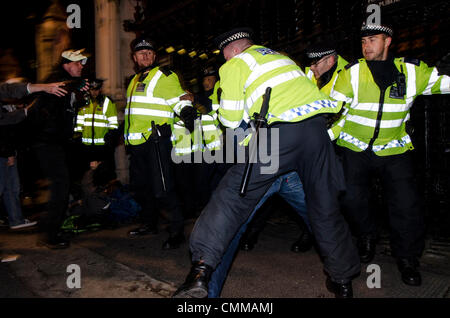 Londra, Regno Unito. 5 novembre 2013. La polizia scontri in piazza del Parlamento, LONDRA, REGNO UNITO, durante le proteste contro i tagli di austerità come parte del global anonimo movimento e maschera di milioni di marzo. Le proteste a coincidere con la celebrazione di Guy Fawkes Day il 5 novembre, quando nel 1605 ci fu un tentativo non riuscito di far esplodere le case britanniche del Parlamento. Credito: Francesca Moore/Alamy Live News Foto Stock