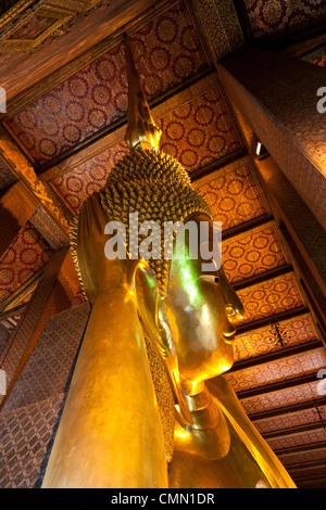 Una bassa angolazione del placcato oro Buddha reclinato la testa (Bangkok - Thailandia). Contre-plongée sur la Tête du Bouddha couché. Foto Stock