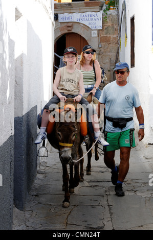 Rodi. La Grecia. Vista dei turisti su asini nel pittoresco villaggio di Lindos. Gran parte della città è zona pedonale e la maggior parte Foto Stock