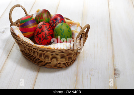 Colorate cinque uova di Pasqua su tovaglioli in rattan Foto Stock