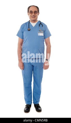 Lunghezza piena vista del medico senior in posa nella parte anteriore della fotocamera Foto Stock