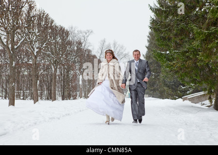 Giovani caucasici di nozze russo matura in esecuzione nel parco innevato. Stagione invernale in Russia Foto Stock