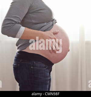 Incinta donna caucasica accarezzando stomaco Foto Stock