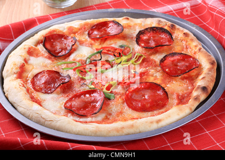 Pane appena sfornato salame pizza su una teglia Foto Stock