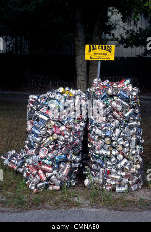 Usato alluminio soda pop e lattine di birra essendo raccolti per il riciclaggio riempire fino a due fili cestini Mesh all'aperto presso un campeggio in Punta Gorda, Florida, Stati Uniti d'America. Foto Stock