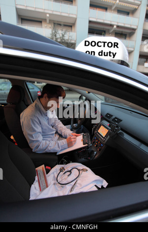 Giovane medico, un medico di paese, medici di medicina generale nel paese, dopo una visita a casa con un malato in un'auto. Foto Stock