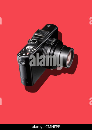 Una fotocamera nero su uno sfondo rosso Foto Stock