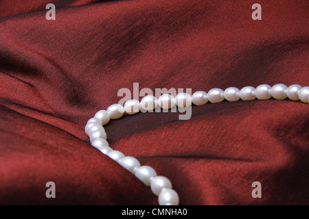 Bianco perla collana in rosso scuro satinato. Foto Stock