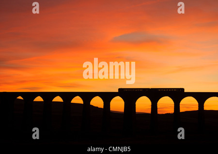 Treno sul viadotto Ribblehead sul Settle-Carlisle linea ferroviaria in Yorkshire Dales National Park, Inghilterra al tramonto Foto Stock