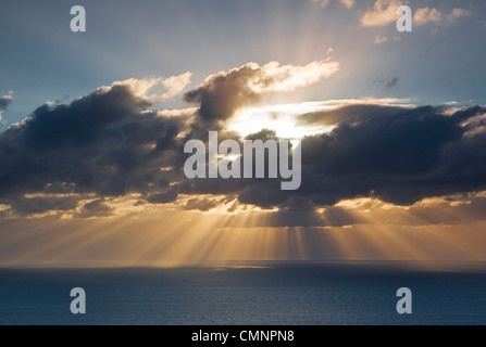 Sun scoppio attraverso le nuvole sopra il mare di corallo. Cooktown, Queensland, Australia Foto Stock