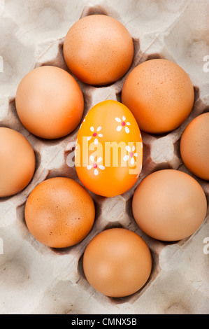Sfondo di pasqua. Uova in contenitore di cartone e un dipinto di uova di pasqua Foto Stock