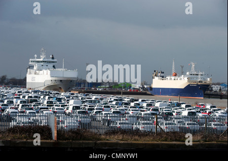 Auto parcheggiate a Grimsby Docks che sono state importate ed esportate dalle navi in background. Foto Stock