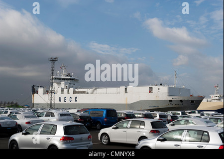 Auto parcheggiate a Grimsby Docks che sono stati importati ed esportati dalla nave in background. Foto Stock