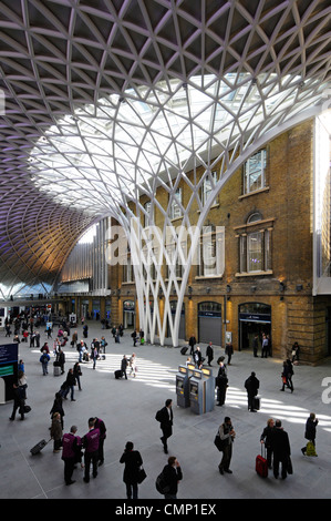 Kings Cross Stazione ferroviaria partenza concourse acciaio strutturale di supporti per la struttura del tetto accanto alla vecchia stazione di pareti in mattoni Foto Stock