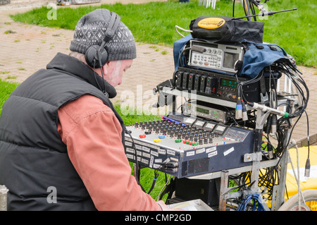 Ingegnere del suono presso un banco di miscelazione ad una pellicola esterna Imposta posizione. Foto Stock
