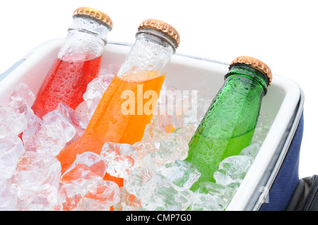 Dettaglio di tre diverse bottiglie di soda in uno scambiatore di calore di piccole dimensioni pieno di cubetti di ghiaccio. Foto Stock