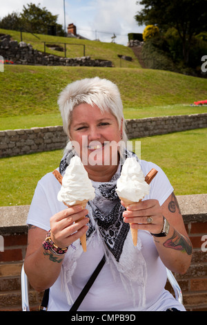 Regno Unito, Inghilterra, Lincolnshire, Cleethorpes, Kingsway, femmina visitatore con due grandi 99 coni gelato nelle sue mani Foto Stock