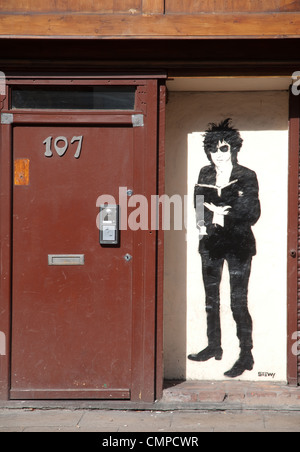 Arte stencil da Stewy delle prestazioni di Salford poeta John Cooper Clarke. Oldham St nel nord del quarto distretto di Manchester. Foto Stock