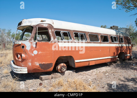 Un vecchio autobus Flxible siede la ruggine in un lotto vacante in Carrizozo, Nuovo Messico. Foto Stock